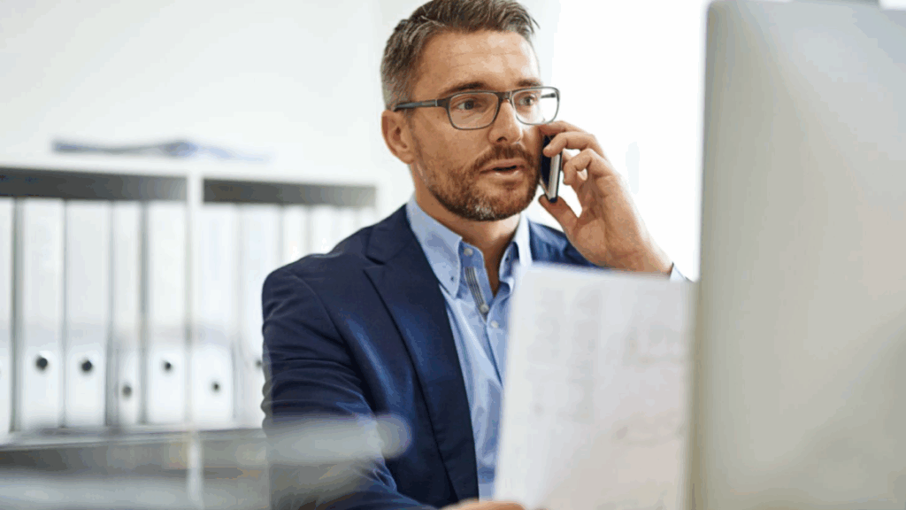 Business owner on the phone reviewing financial documents, representing the challenges and risks of choosing debt settlement and why settlement is not the best solution for managing MCA debt.